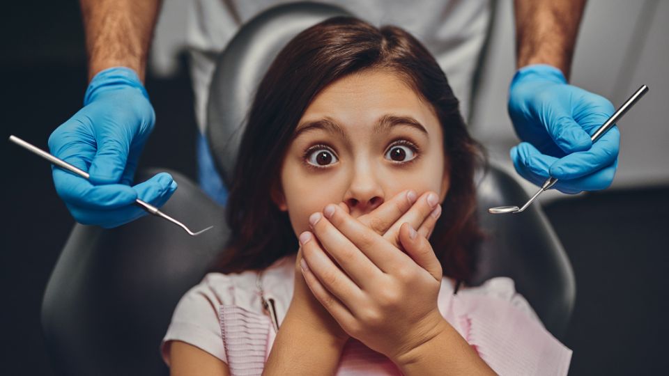 Scared Girl Covering Her Mouth With Hands While Going Through Dental Treatment