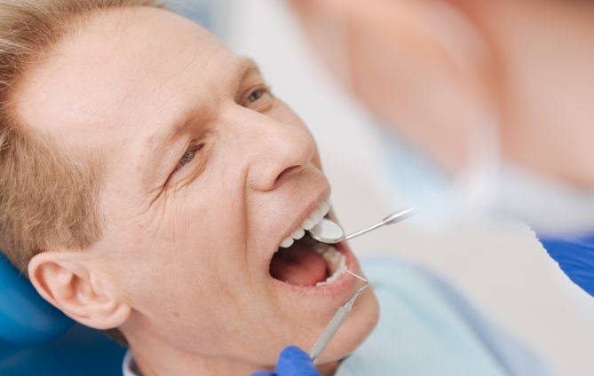 A Man Receiving Dental Care From A Dentist