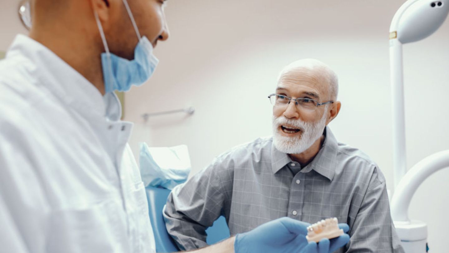 Dentist Explaining Denture Treatment To Patient